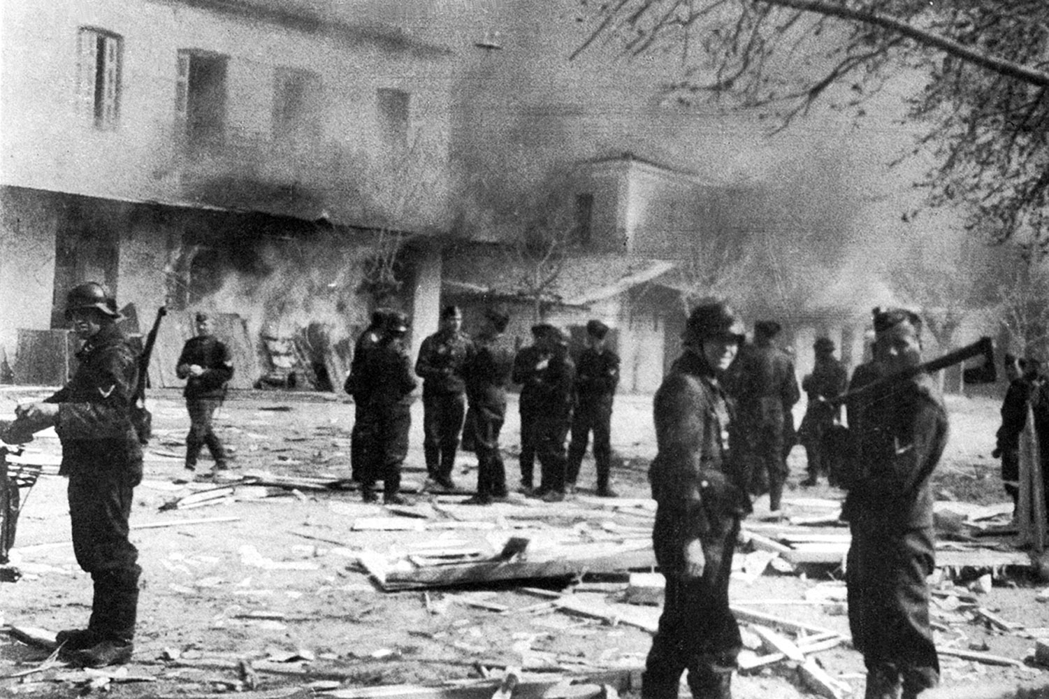 Deutsche Soldaten am 10. Juni 1944 vor brennenden Häusern in Distomoam 